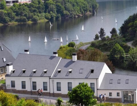 Habitación moderna del Hotel Ferramenteiro con grandes ventanales y vistas al río Miño en Portomarín.
